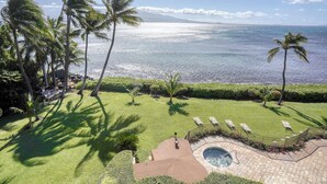 Um resort com piscina, palmeiras e vista para o oceano.