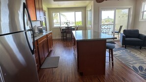 Une cuisine moderne avec des meubles en bois, un réfrigérateur en acier inoxydable et un grand îlot central.