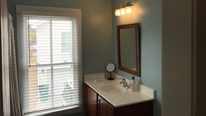 A bathroom with a window, sink, mirror, and light fixture. - Intimate low country Carriage House with gorgeous appointments! (Bluffton)