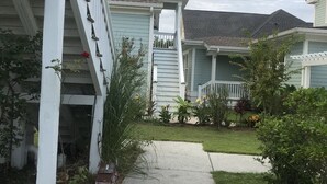 A residential area with a pathway leading to a house with a porch and a small garden. - Intimate low country Carriage House with gorgeous appointments! (Bluffton)