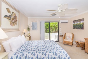 A hotel room with a bed, a ceiling fan, a chair, and a view of the outdoors. - Steps to Beach Hidden Gem Boutique Hotel (Juno Beach)