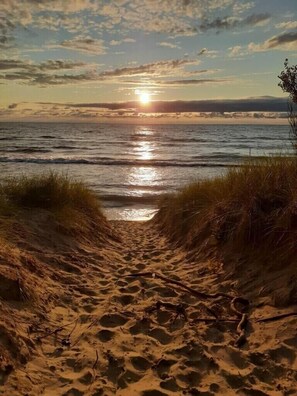 A sandy beach path leading to the ocean with a sunset in the background. - Beautiful Lake View, Newly-Remodeled Home~Contemporary, (Saugatuck)
