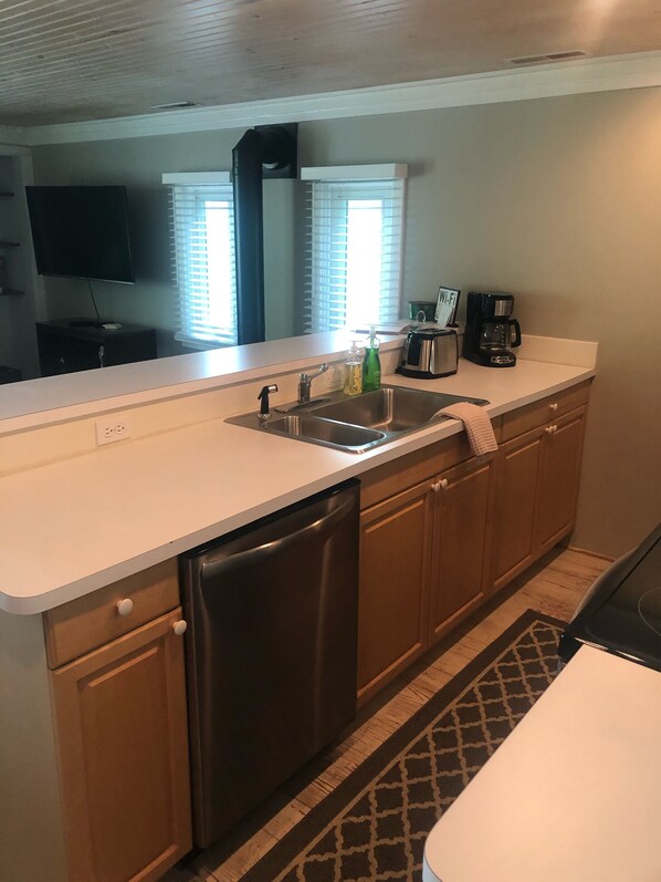 A compact kitchen with a dishwasher, a sink, and a coffee maker. - Beautiful Lake View, Newly-Remodeled Home~Contemporary, (Saugatuck)
