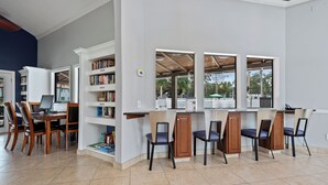A modern kitchen with a dining area, built-in bookshelves, and large windows. - Stunning & Serene, Minutes to Anna Maria Island, IMG & More (Bradenton)