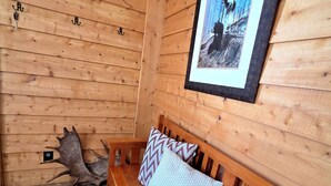 A wooden bench with patterned pillows against a wooden wall with a framed picture. - Lake Front Rental With Chugach Mountain Views! (Glennallen)
