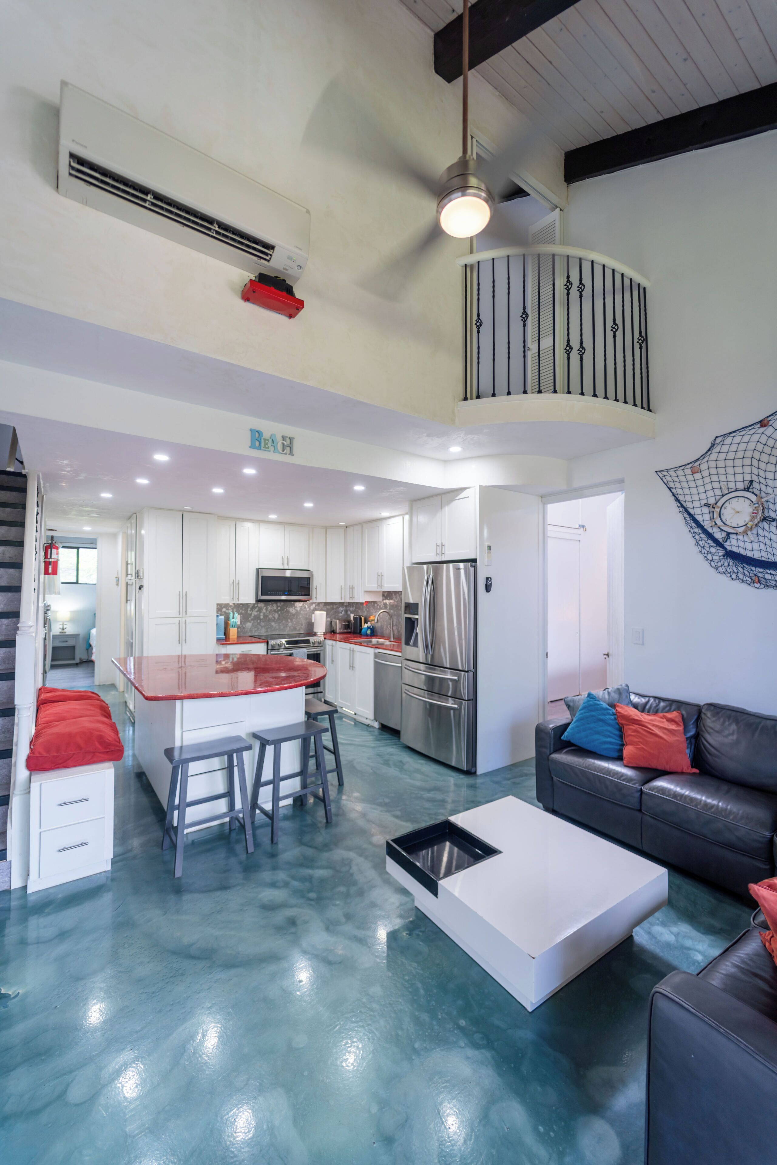 A modern kitchen with white cabinets, stainless steel appliances, and a central island with stools.