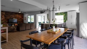 A modern kitchen with a wooden dining table, black chairs, and a chandelier. - ☆Featured on HGTV☆ Heated Pool, SleepNumber Beds, Beach Cruisers (Largo)