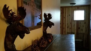 A wooden table with two moose head sculptures and pine cones. - Enjoy Our Mountain Retreat in The Teton Valley adjacent to Jackson Hole (Victor)