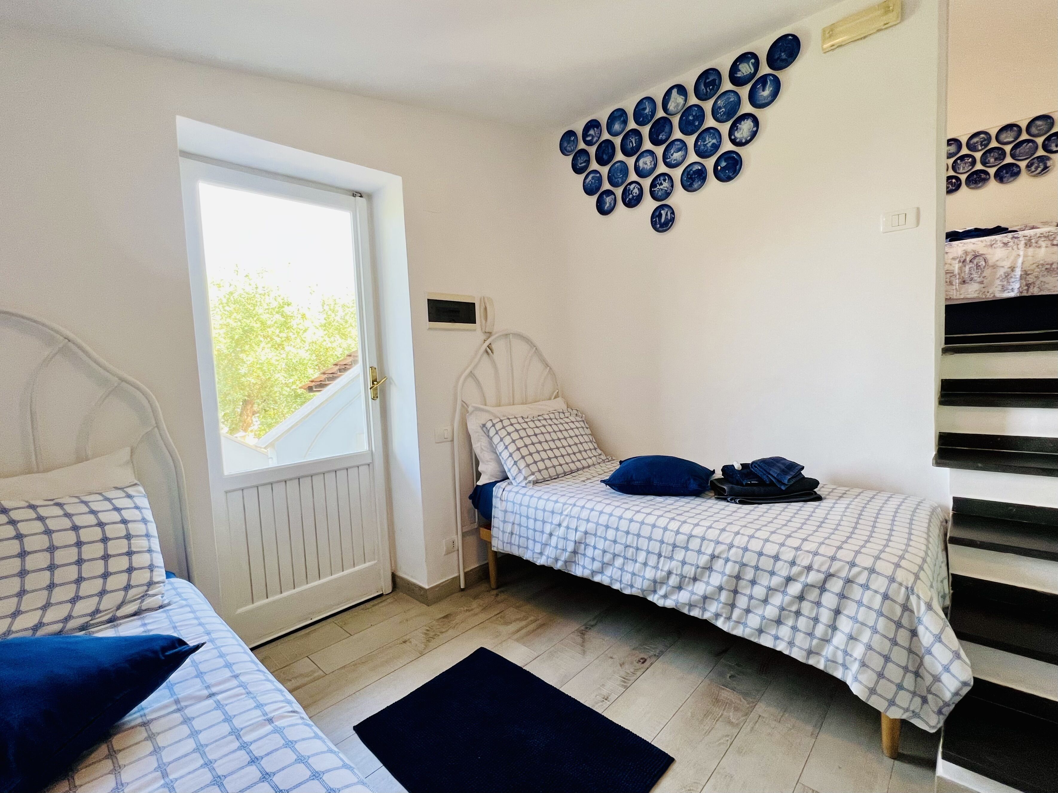 Quarto com duas camas, uma janela, aquecedor fixado na parede e uma escada.