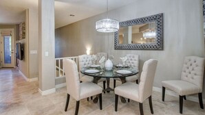 A dining area with a round table, six chairs, and a chandelier. - Luxury Living in Kierland Greens (Scottsdale)