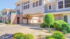 A two-story residential building with a garage, a covered driveway, and well-maintained landscaping. - Luxury Living in Kierland Greens (Scottsdale)