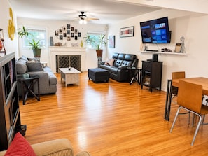 Una sala de estar con chimenea, un sofá, una mesa de centro, un televisor y un comedor.