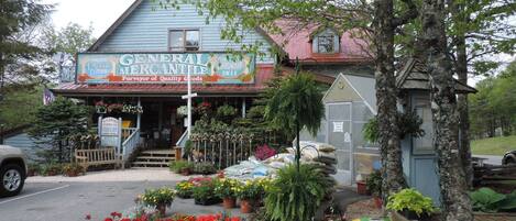 Un edificio con un letrero que dice "General Mercantile Deli" y una floristería al frente.