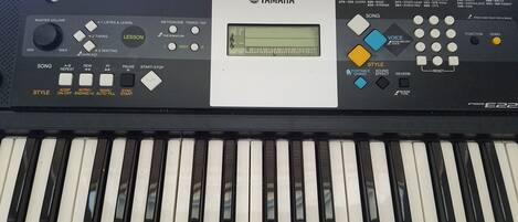 A Yamaha keyboard with various controls and a digital display.