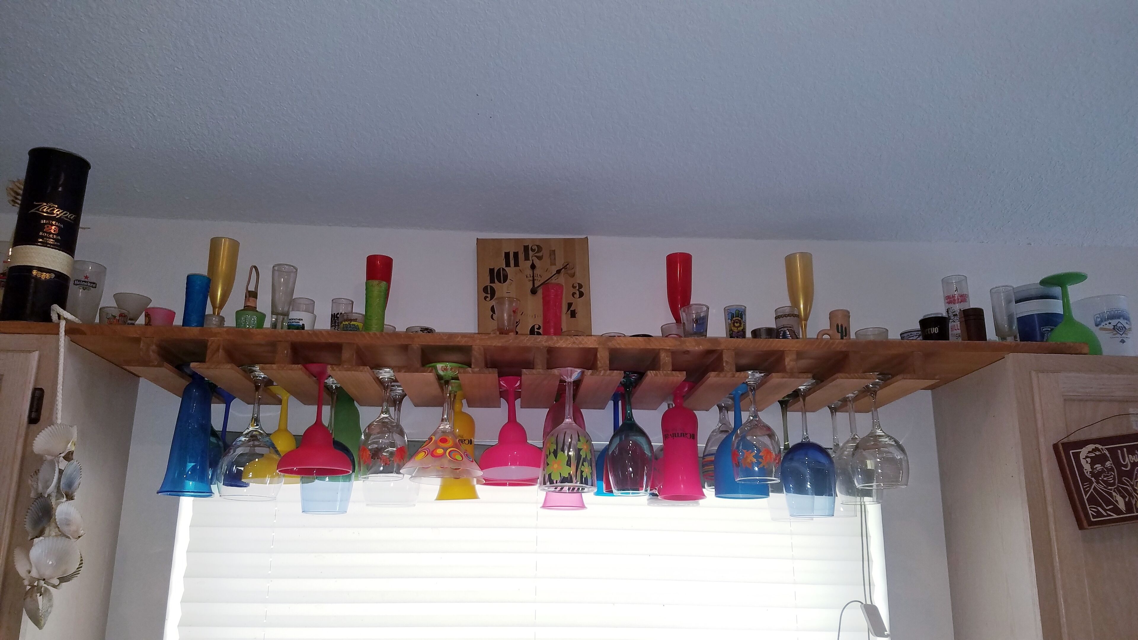 Una repisa de madera con diferentes vasos y botellas.