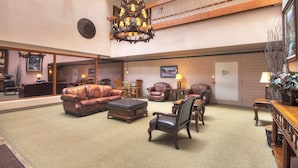 A spacious lobby with leather sofas, a chandelier, and a high ceiling. - Studio Premier Condo | Ski-in/Skit-out Access (Breckenridge)