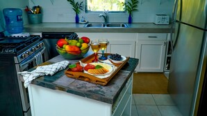 A kitchen with a marble countertop, a sink, a stove, and a refrigerator. - The ONLY house with POOL for rent in Spanish Wells! Five star service. (Spanish Wells)