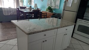 A kitchen with a granite countertop, white cabinets, and a built-in oven.