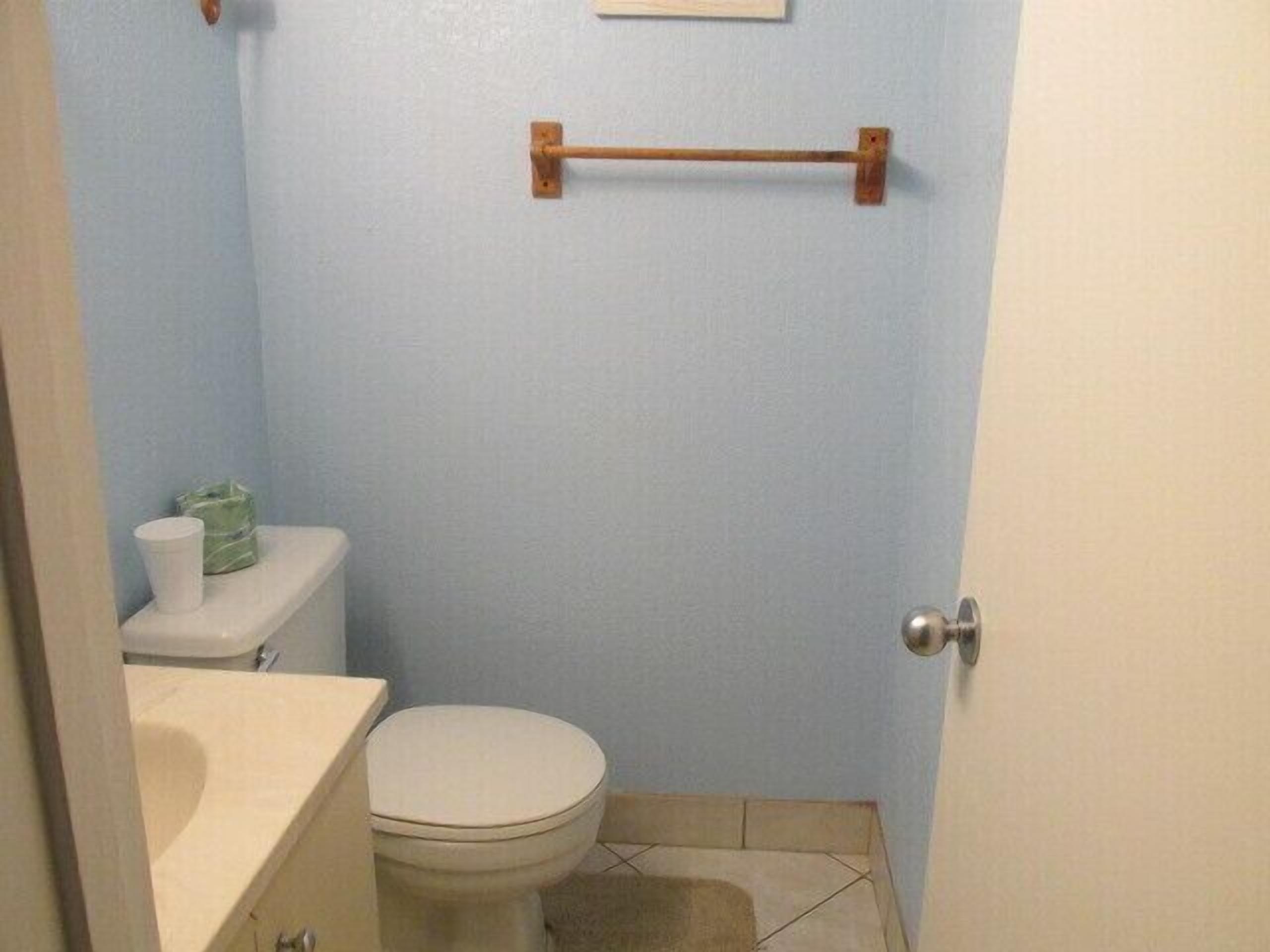 Une petite salle de bain comprenant des toilettes, un lavabo et un porte-serviettes.