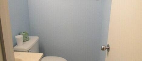 Une petite salle de bain comprenant des toilettes, un lavabo et un porte-serviettes.