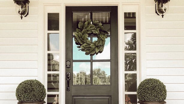 A front door with a wreath, two potted plants, and a wooden floor. - Willow Pond Nashville, A Private Luxury Five-Star Farmhouse Great for Lg Groups! (Pleasant View)