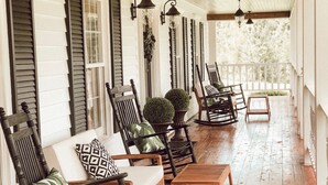 A covered porch with wooden flooring, rocking chairs, and a bench. - Willow Pond Nashville, A Private Luxury Five-Star Farmhouse Great for Lg Groups! (Pleasant View)