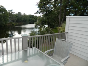 Relax in a serene lakeside setting with a tranquil view of lush greenery.