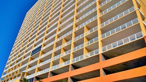 Un edificio alto con varios balcones y un cielo azul despejado.