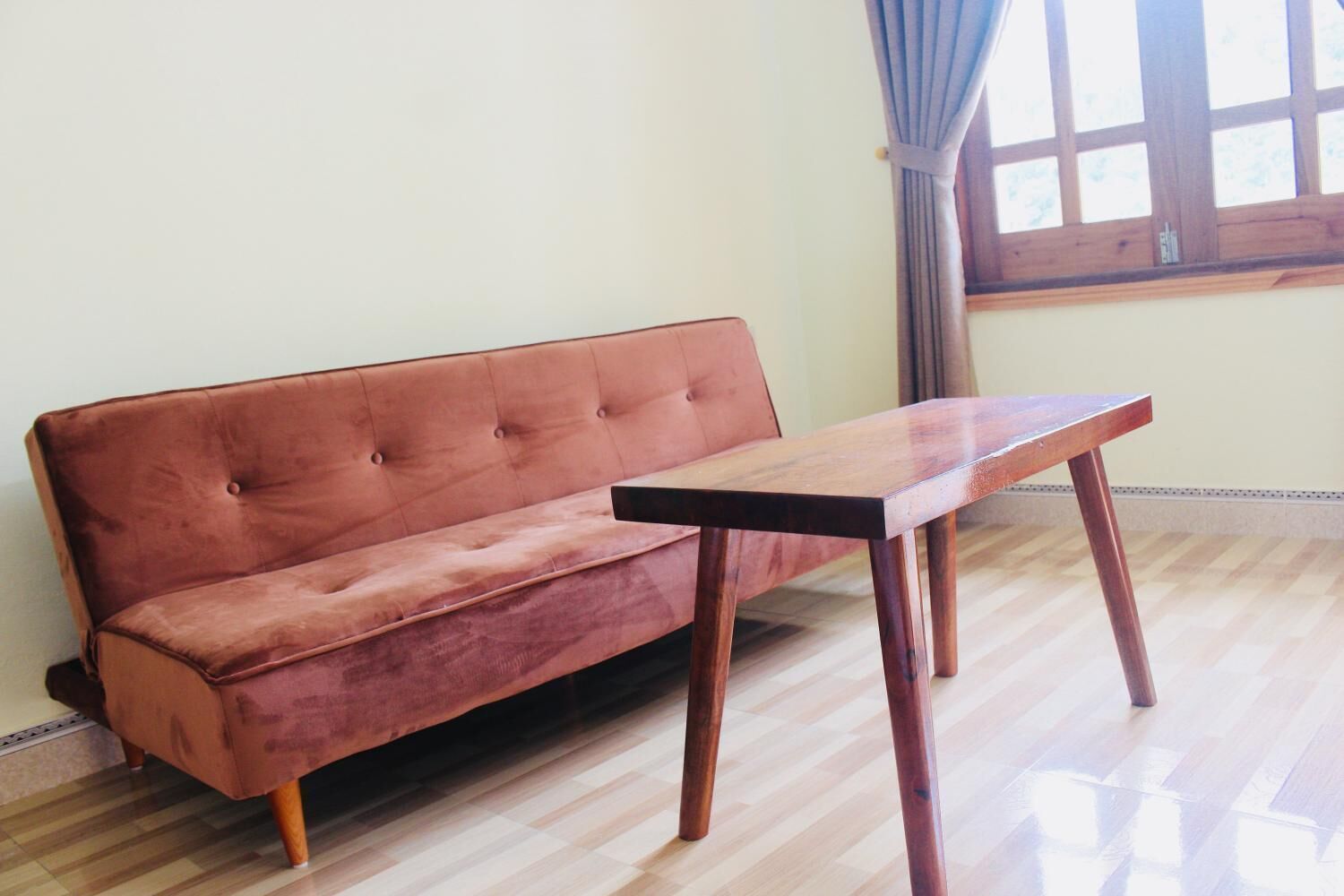Une pièce avec un plancher en bois, un canapé et une table.