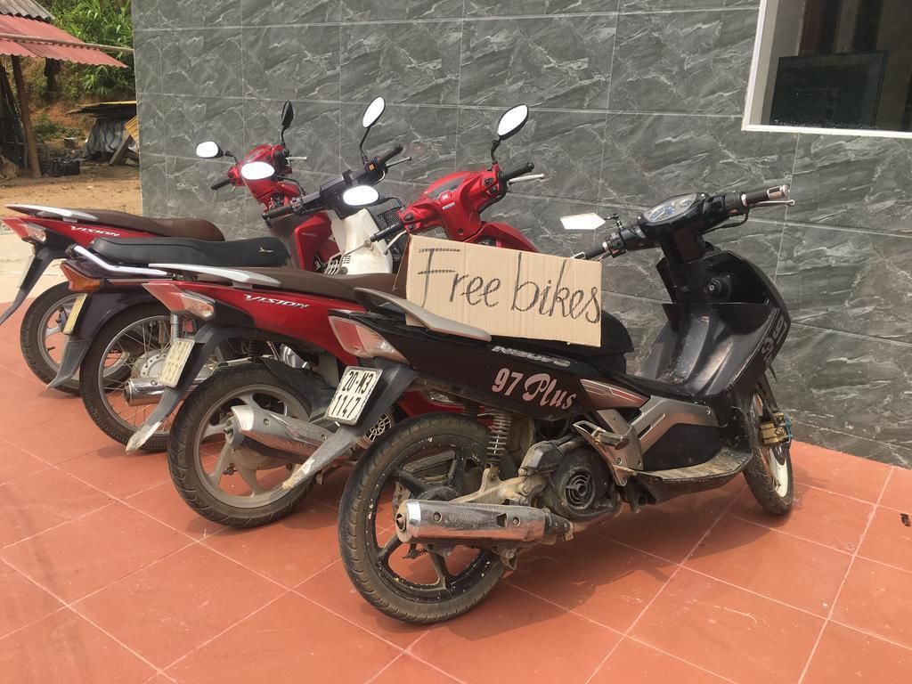 Tres motocicletes aparcades davant d'un edifici amb un cartell que diu "Free bikes".