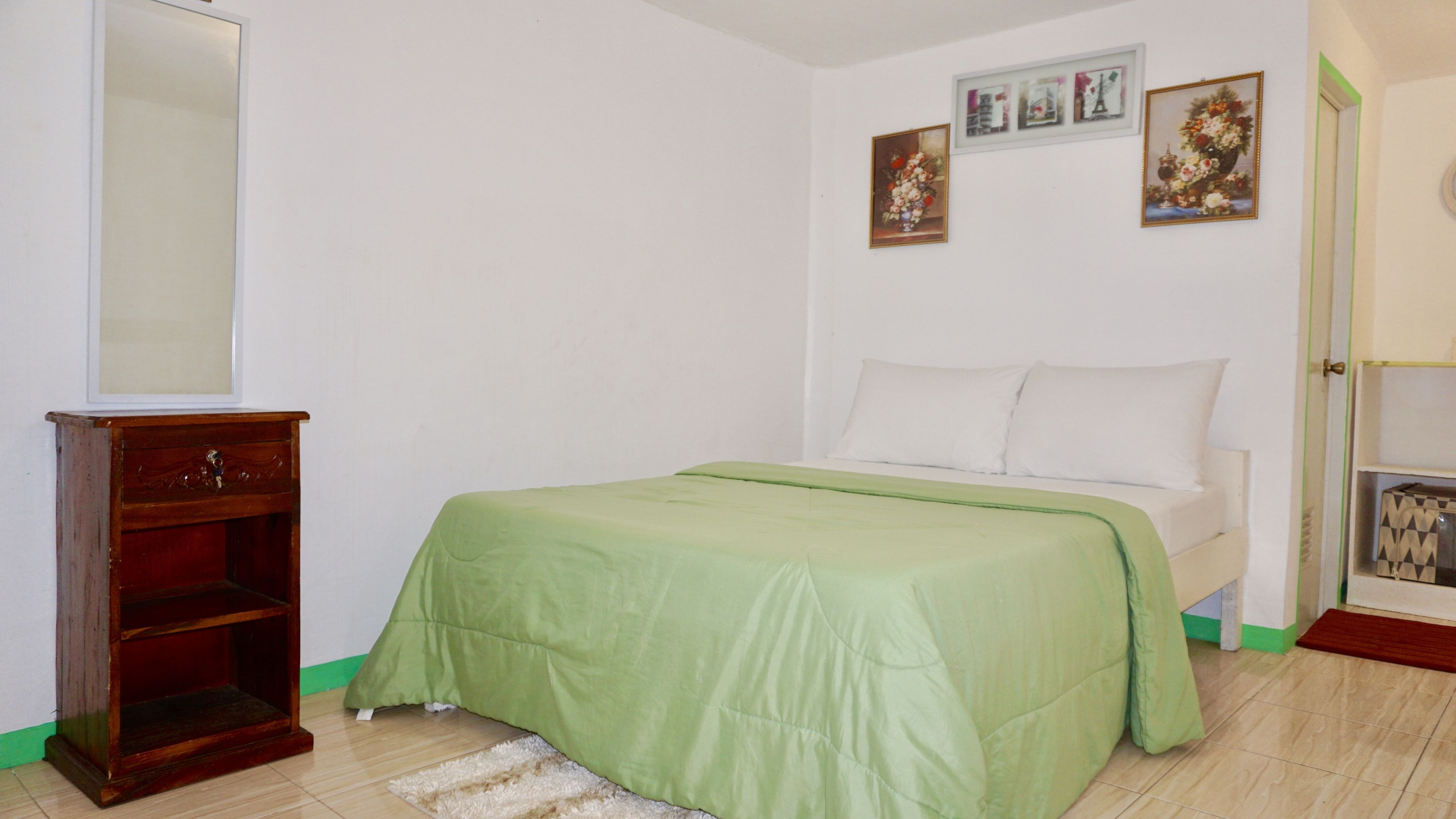 Un dormitorio con una cama, un aparador de madera y un espejo.