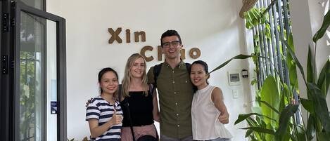 A group of people standing in a hallway with a sign reading "Xin Chuo".