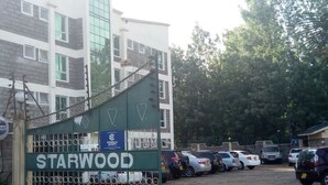 Una entrada con puerta cerrada a Starwood Garden, con un estacionamiento al frente.