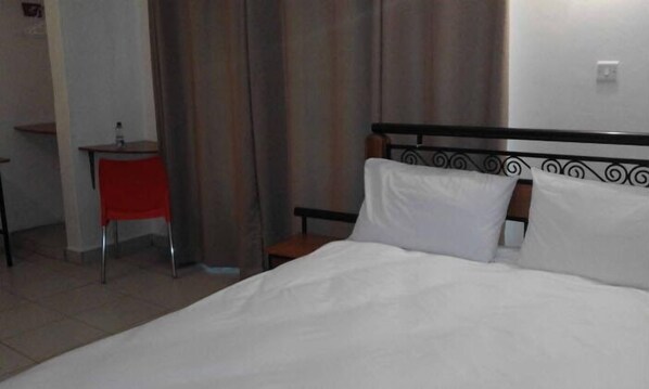 Una habitación de hotel con una cama, un escritorio y una silla.