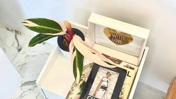 A white box with a framed photo and a book titled "CHANEL" by Emma Baxter and Waight, placed on a marble floor.