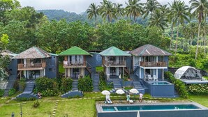 Ein Resort mit mehreren bungalowsähnlichen Gebäuden, jedes mit einem Balkon und einem Pool.