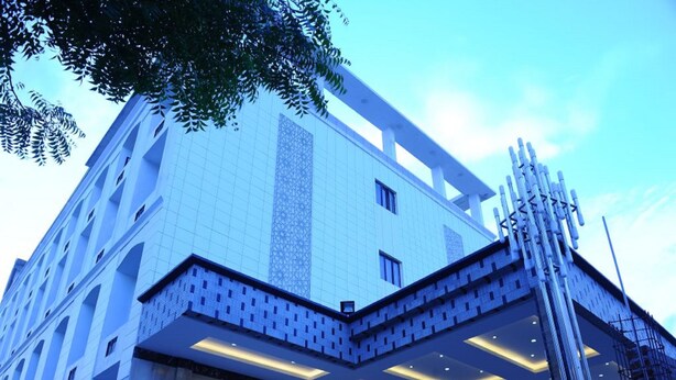 A modern building with a prominent vertical column, large windows, and a patterned facade.