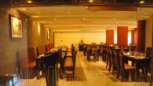 A conference room with long tables and chairs, equipped with nameplates and table settings.