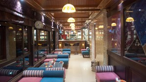 A bar area with seating, a bar counter, and a clock on the wall. - Hotel Southgate Shimla (Shimla)