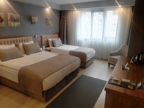 A hotel room with two beds, a desk, and a chair. - Oytun Park Hotel (Çanakkale)