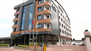 A modern hotel building with multiple floors, large windows, and a prominent sign for the Oytun Hotel. - Oytun Park Hotel (Çanakkale)