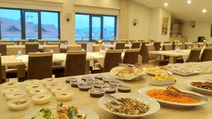 A dining area with multiple tables set for a buffet, featuring a variety of dishes including salads, meats, and desserts. - Oytun Park Hotel (Çanakkale)