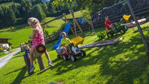 A playground with a slide and a swing set. - Tobhartbauer (Dorfgastein)