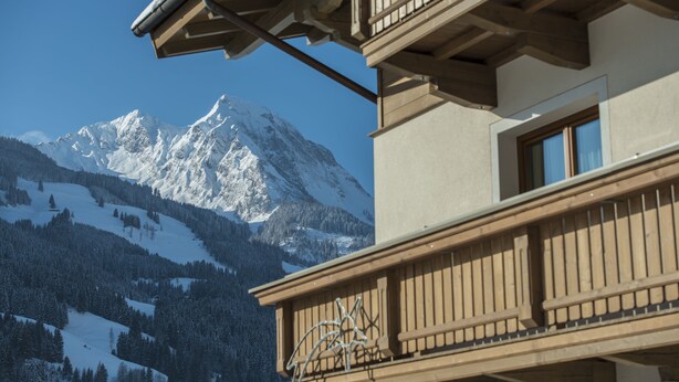 A mountain with a snow-covered peak, a wooden balcony, and a clear blue sky. - Tobhartbauer (Dorfgastein)
