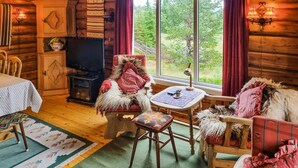 A cozy cabin interior with a wooden interior, a television, a dining area, and a view of the outdoors. - 3 bedroom stunning home in Sjusjøen (Sjusjøen)