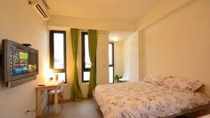 A hotel room with a bed, a desk, a chair, a TV, and a window with curtains. - Hellostay B&B Hualien Jian (Ji'an)