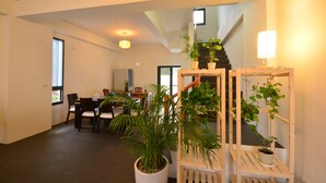A spacious living area with a dining table, chairs, and potted plants. - Hellostay B&B Hualien Jian (Ji'an)