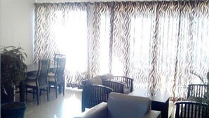 Una sala de estar con sofá, sillas, una mesa de comedor y una planta en maceta.