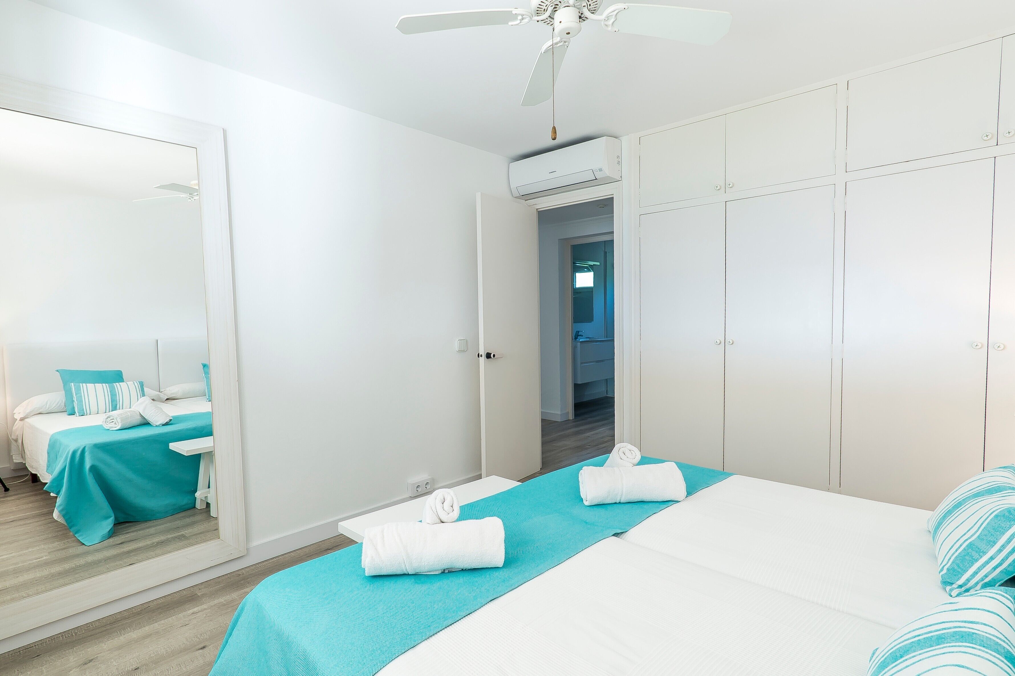Une chambre d’hôtel équipée d’un lit, d’un miroir, d’une armoire et d’un appareil de climatisation.