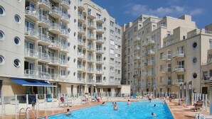 Una piscina circondata da edifici residenziali a più piani con balconi.